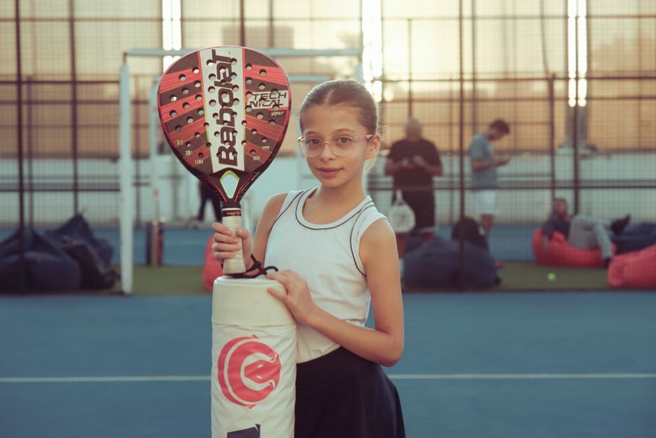 Een premium padelracket met ergonomisch ontwerp en geavanceerde materialen op een speelveld.