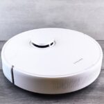 Een moderne robotstofzuiger zonder dweil die een vloer efficiënt schoonmaakt in een huiselijke omgeving.